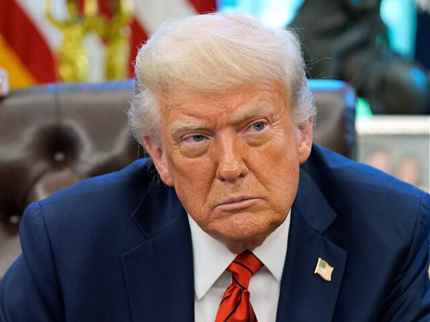 President Donald Trump listens to a question from a reporter as he signs executive orders