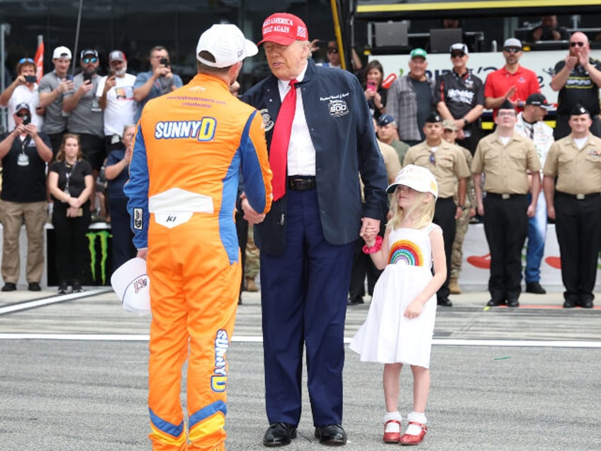 U.S. President Donald Trump is greeted by Ricky Stenhouse Jr., driver of the #47 SUNNYD Ch