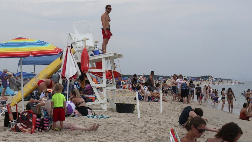 A lifeguard looks out at people swimming