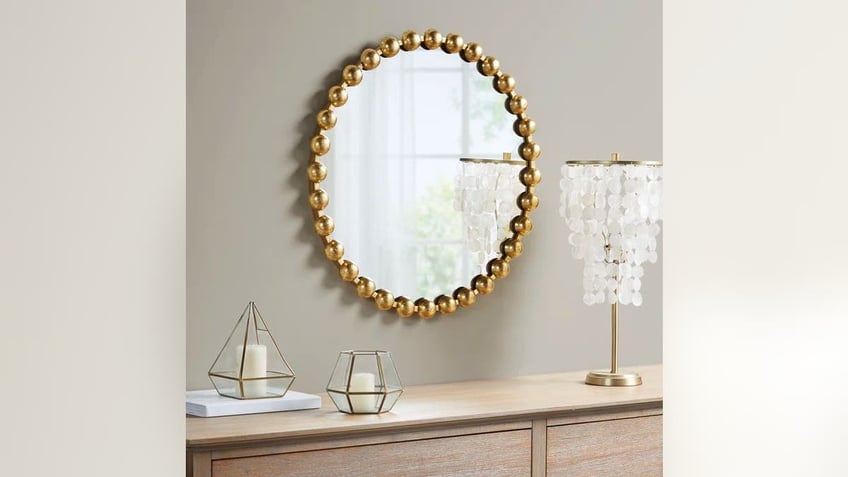 Add some glamour to your living space with this beaded mirror.