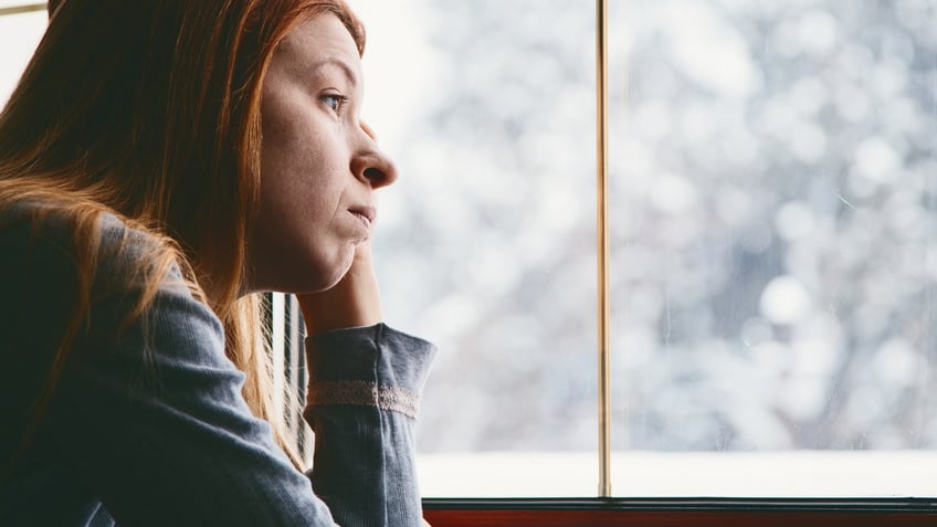 Sad woman looking out window