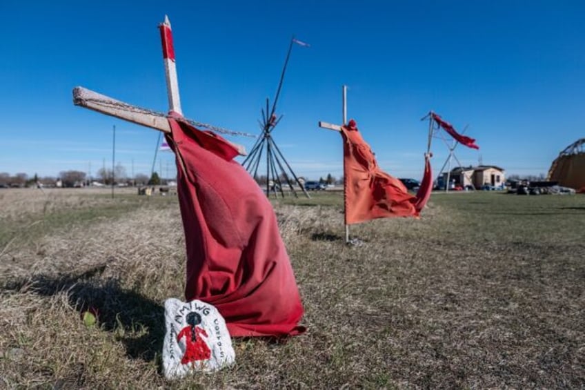 Red dresses on crosses are displayed at the entrance of a makeshift camp near near the Pra