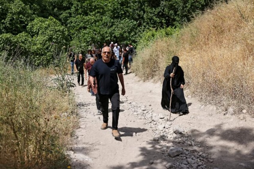 Arab Israelis walk through the overgrown ruins of the Palestinian village of Al-Lajjun, de