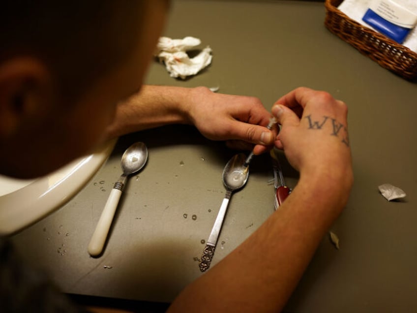 Drugs are prepared to shoot intravenously by a user addicted to heroin on February 6, 2014