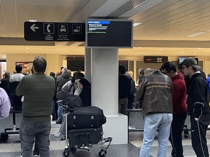 BEIRUT, LEBANON - JANUARY 07: Passengers wait as a cyberattack targets the screens of departures and arrivals at a Beirut airport in Lebanon on January 7, 2024. The hacked screens at Rafic Hariri airport displayed an anti-Hezbollah content and messages opposing the war in southern Lebanon. (Houssam Shbaro/Anadolu via Getty)