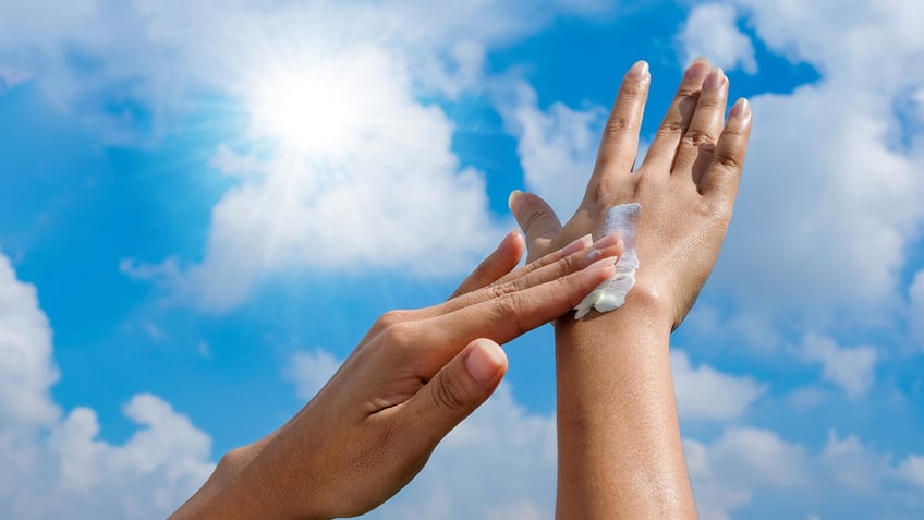 Person rubbing in sunscreen to hand