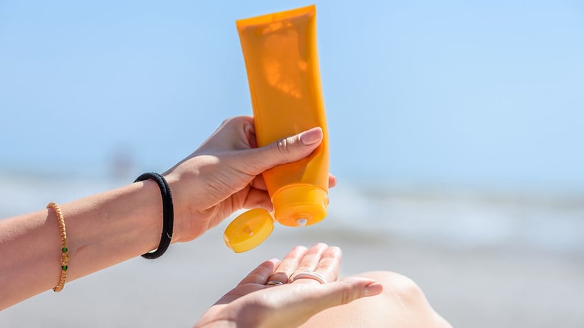 Sunscreen being put on hand