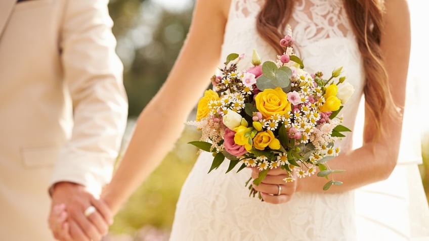 Couple At Wedding Holding Hands