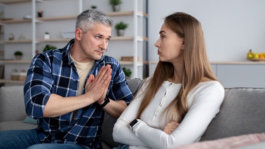 Offended middle-aged woman sitting on sofa after family conflict.