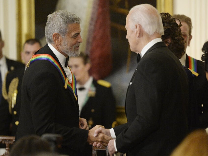 US President Joe Biden, right, greets actor George Clooney during the Kennedy Center honor