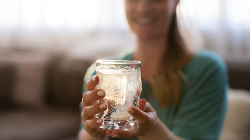 woman holding glass of sparkling water