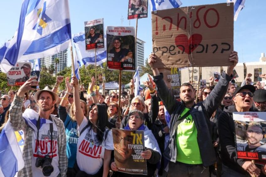 People gather at Tel Aviv's "Hostages Square" to watch the release of three Israelis held