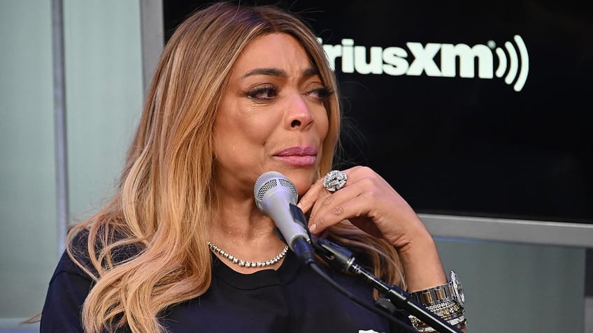 Wendy Williams looks emotional in front of a microphone at a SiriusXM Town Hall