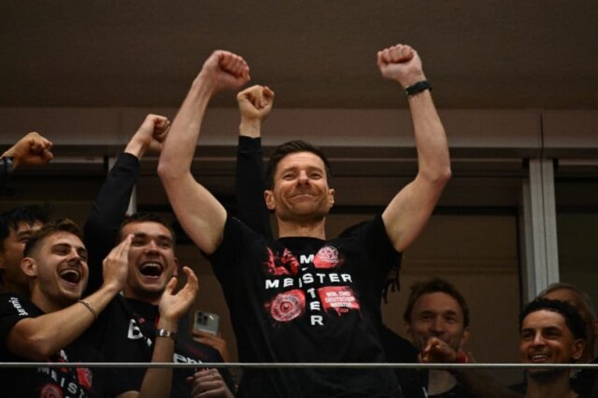 Bayer Leverkusen coach Xabi Alonso celebrates with his players after winning the Bundeslig