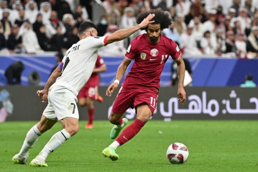 Qatar's forward #11 Akram Afif and Palestine's defender #07 Musab al-Battat during the match between Qatar and Palestine