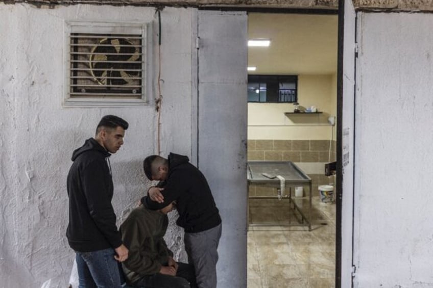 Mourners gather at the morgue where the body of Yamen Mohammed Husseti, 16, was laid ahead of his funeral in the occupied West Bank