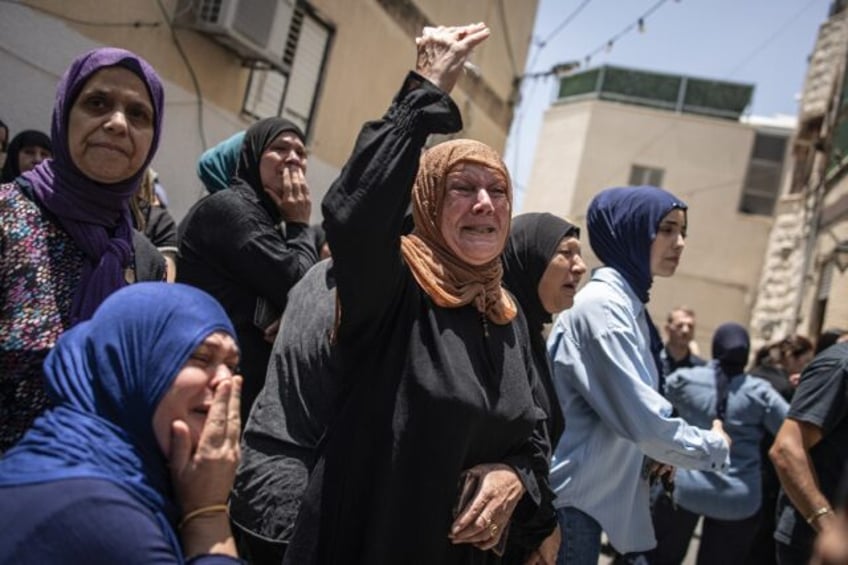 Mourners at a funeral for victims of an Iranian missile attack which destroyed a three-sto