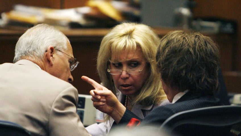 Roger Rosen (L) and Linda Kenny Baden (C) speak with music producer Phil Spector in court