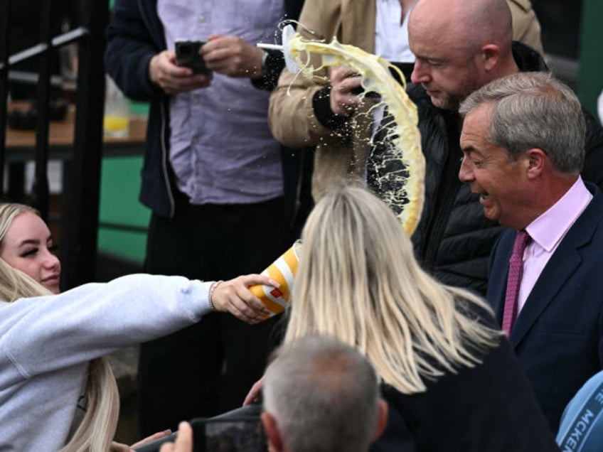 TOPSHOT - A person throws the contents of a drinks cup in the face of newly appointed lead