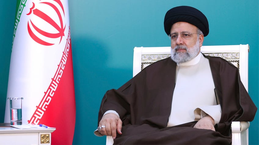 Ebrahim Raisi sitting in a white chair