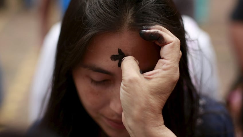 Woman getting ashes on Ash Wednesday