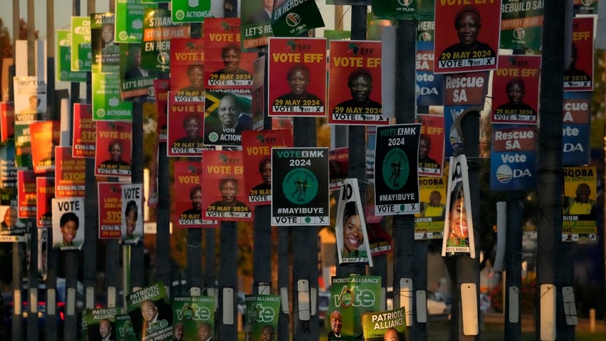 An array of election posters from various political parties are displayed on poles in Pretoria, South Africa