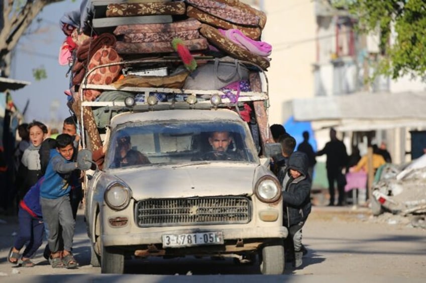 Palestinian children help push a heavily laden vehicle in Gaza's Bureij refugee camp as re