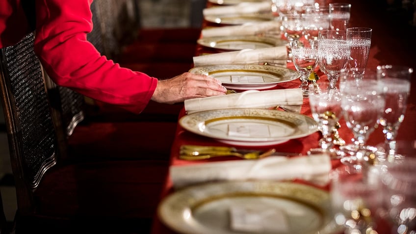 Person setting table at Inaugural Luncheon.