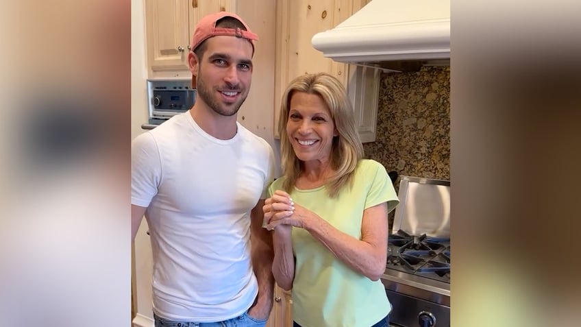 Vanna White in a lime green t-shirt smiles next to her son Nikko in a white t-shirt and backwards hat