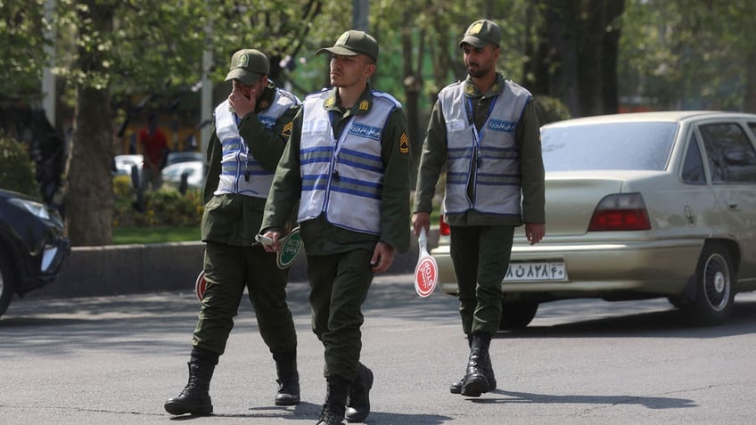 Iran's police forces walk on a street amid the implementation of the new hijab surveillance in Tehran