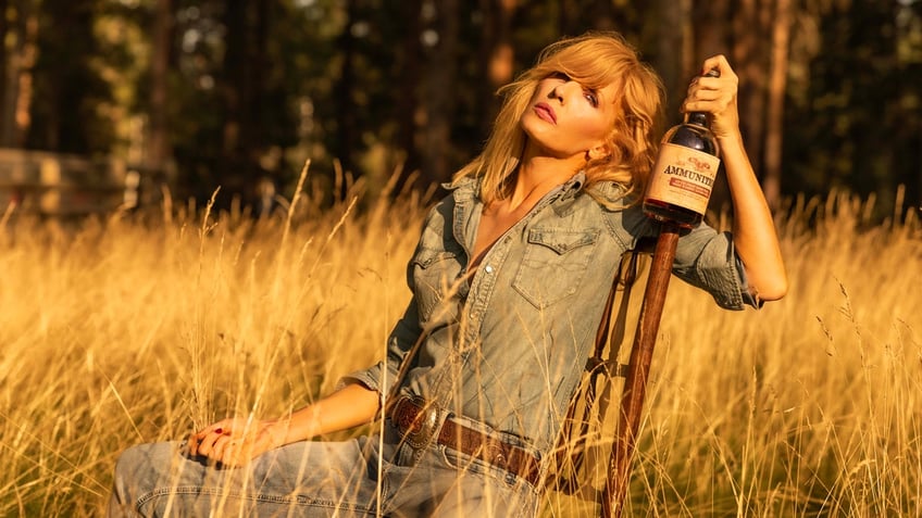 "Yellowstone" actress Kelly Reilly holds a bottle of Ammunition whiskey during a photography session for the California-based whiskey and wine maker.