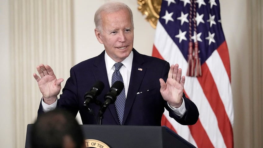 President Biden at lectern with hands raised