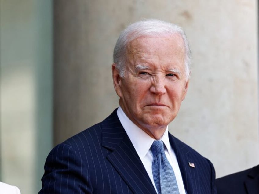 US President Joe Biden (C) flanked by US first lady Jill Biden (L), waves as he is welcome