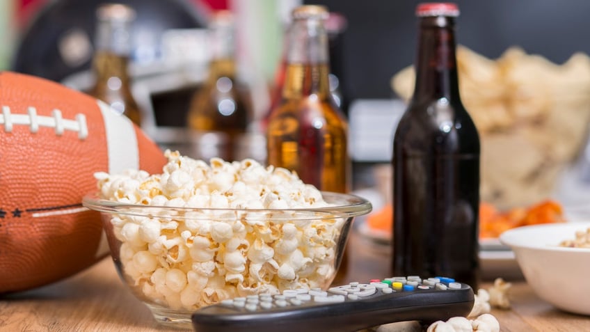 Popcorn, beer, a TV remote, and a football