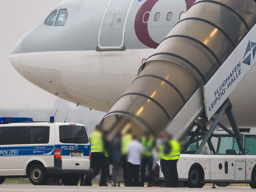 18 July 2025, Saxony, Schkeuditz: People boarding a Qatar Airways plane with Federal Polic
