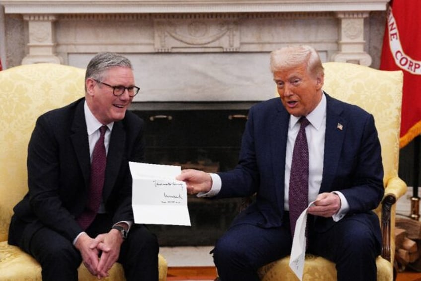 Donald Trump holds an invitation letter from Britain's King Charles III during a meeting w
