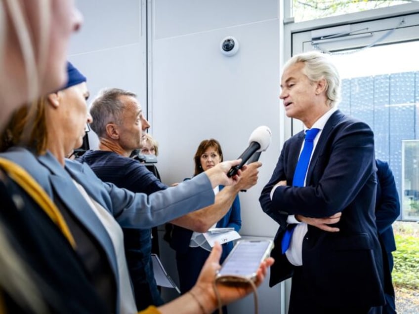 PVV leader Geert Wilders (R) answersw journalists' questions after the verdict in the case