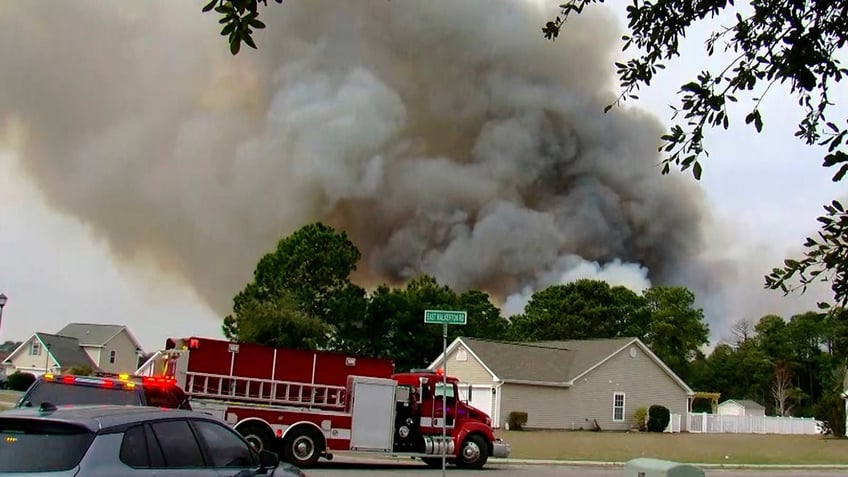 Crews work to contain a fire in the Carolina Forest area west of the coastal resort city of Myrtle Beach, S.C., Sunday, March 2, 2025, where residents were ordered to evacuate several neighborhoods.