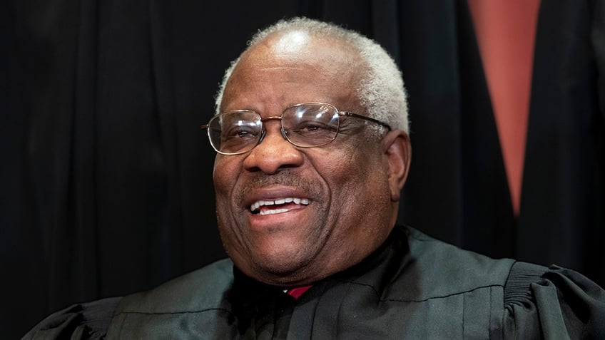 Associate Justice Clarence Thomas, appointed by President George H. W. Bush, sits with fellow Supreme Court justices for a group portrait at the Supreme Court Building in Washington, Friday, Nov. 30, 2018. Thomas was a regular participant in remote oral arguments during the COVID-19 pandemic after almost never asking questions to lawyers when the court heard its cases in person. (AP Photo/J. Scott Applewhite)