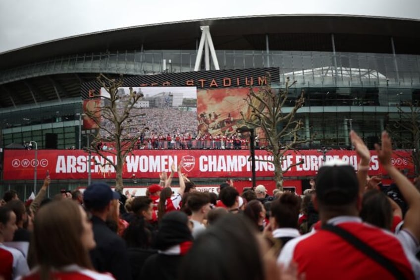 Arsenal's players celebrate with the UEFA Women's Champions League trophy during a parade
