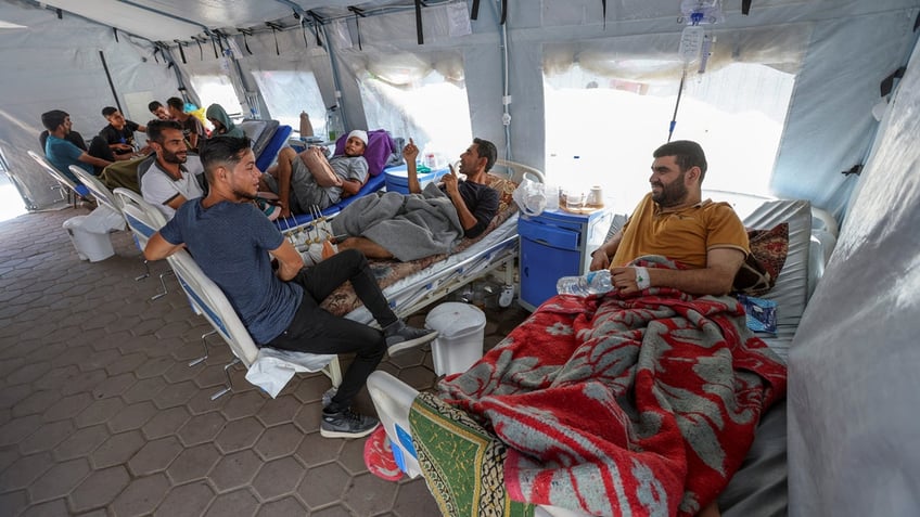 Wounded Palestinians are seen on beds as they receive treatment at Al-Aqsa hospital.