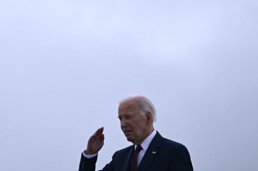 US President Joe Biden salutes as he boards Air Force One at Joint Base Andrews in Marylan