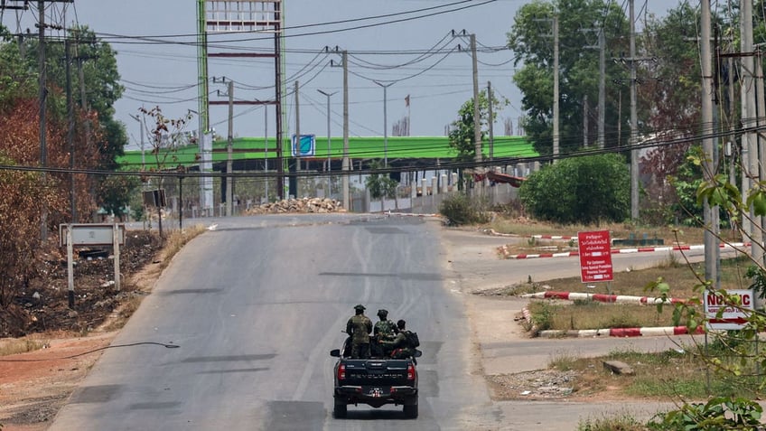 Soldiers from the Karen National Liberation Army patrol on a vehicle