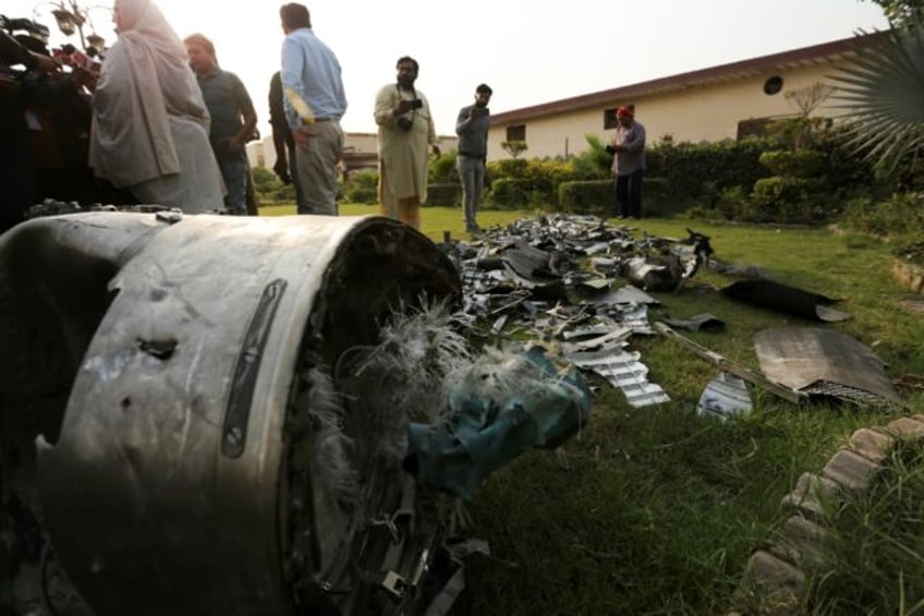 Journalists film missile fragments at the compound of an Islamic seminary after Indian str