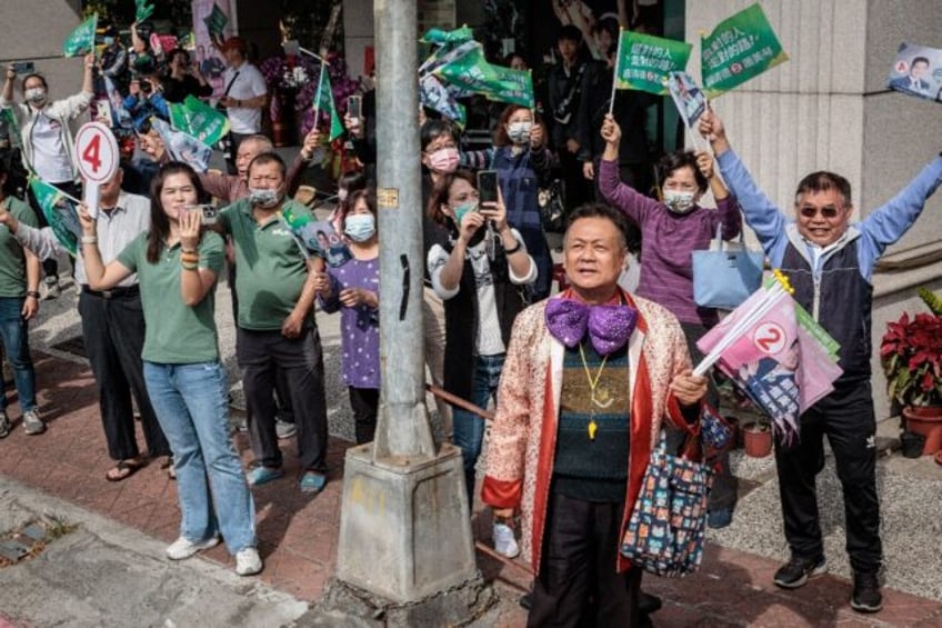 Suppporters of the ruling Democratic Progressive Party watch a campaign motorcade tour of presidential candidate Lai Ching-te in Kaohsiung on January 8, 2024