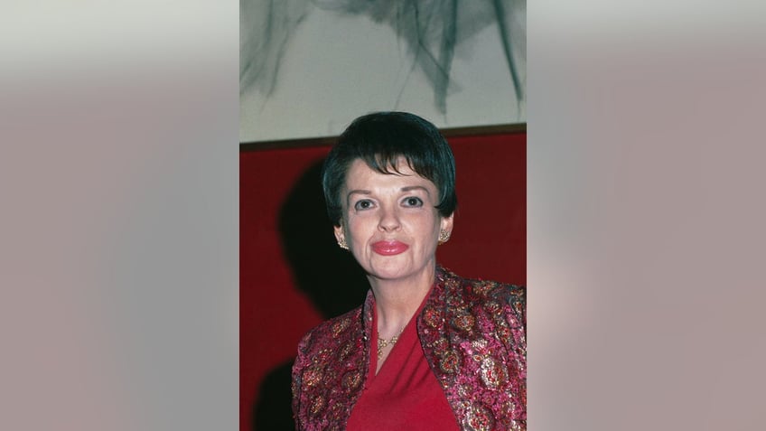 Judy Garland wearing a red blouse and a multicolored cardigan