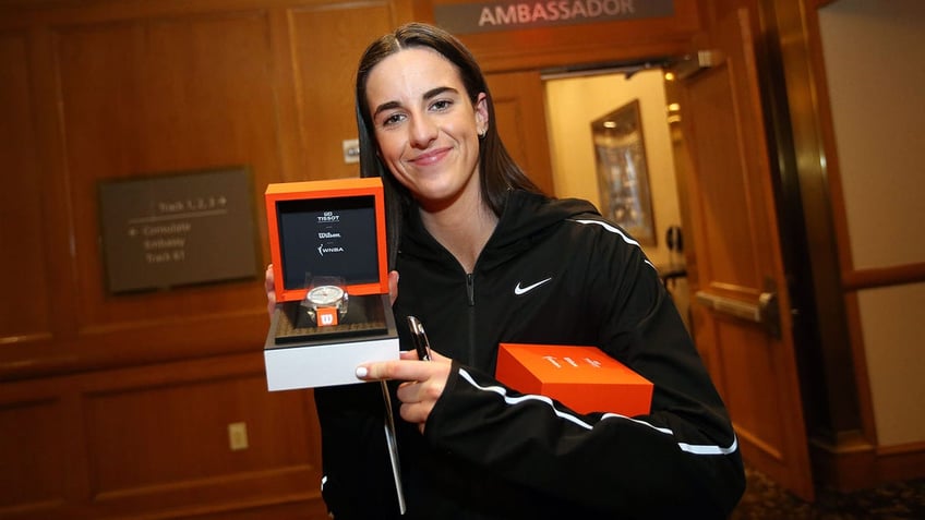 Caitlin Clark holds a watch