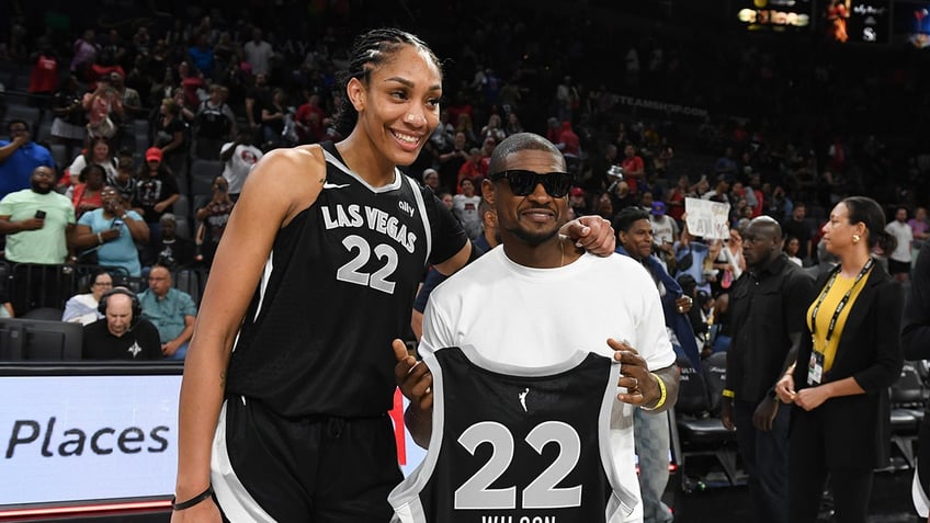 Aja Wilson takes a photo with singer Usher