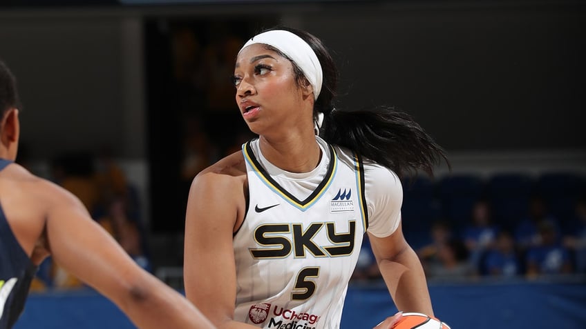 Angel Reese looks to pass during a WNBA game