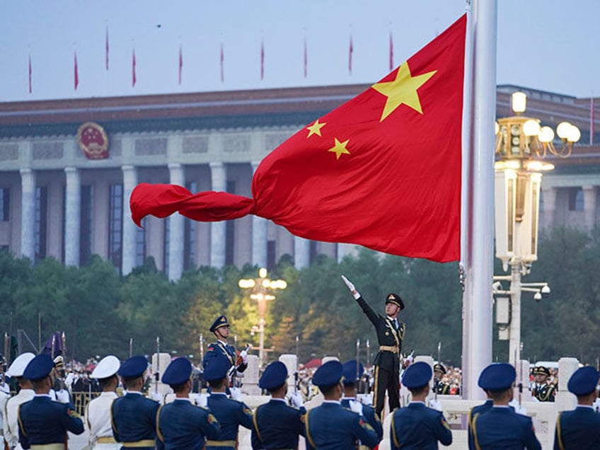 In this photo released by Xinhua News Agency, a member of the Chinese honor guard unfurls